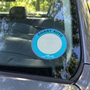 Round branded licence disc sticker on a car windscreen